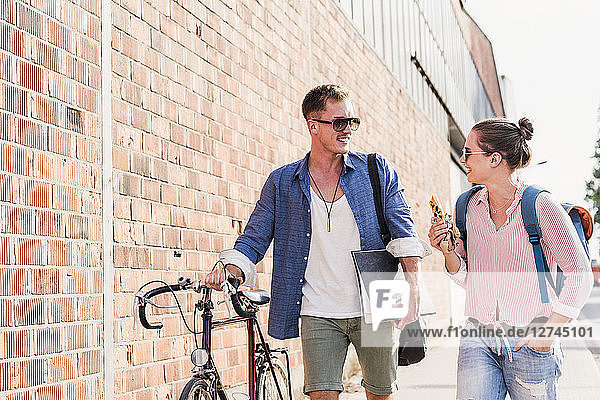 Young couple with bicycle walking and talking