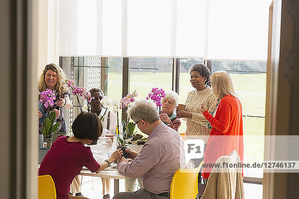 Active seniors enjoying flower arranging class in community center