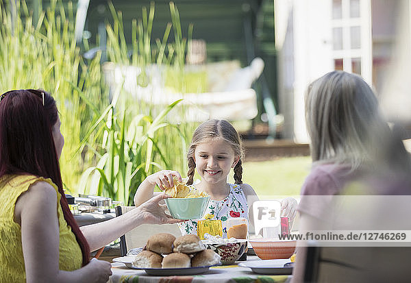Lesbian couple and daughter enjoying lunch on patio