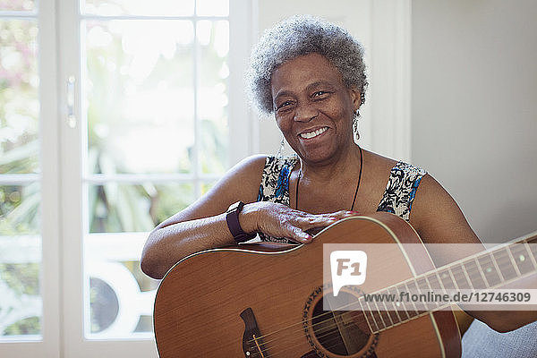 Portrait smiling  confident active senior woman playing guitar