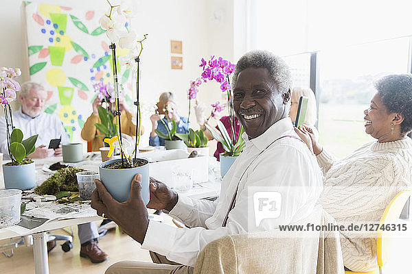 Portrait confident active senior man enjoying flower arranging class