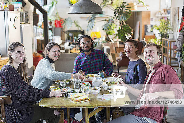 Porträt lächelnd  zuversichtlich  junge Erwachsene Mitbewohner Freunde genießen das Mittagessen am Tisch Wohnung