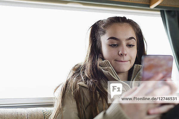 Teenager-Mädchen schreibt SMS mit Smartphone