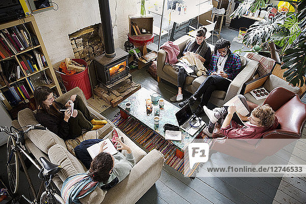 Young adult roommate friends hanging out in apartment living room