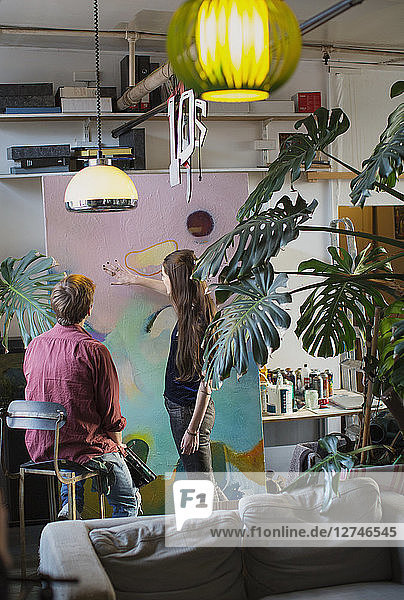 Künstler diskutieren über ein großes Gemälde in der Wohnung