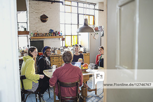 Junge Mitbewohner und Freunde am Frühstückstisch in der Wohnungsküche