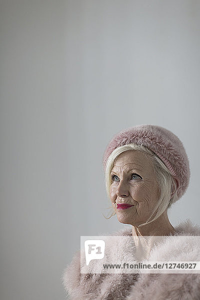 Portrait confident  elegant senior woman wearing pink fur