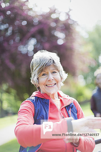 Portrait smiling  confident active senior woman checking smart watch in park