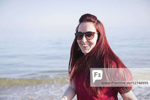 Portrait smiling  confident woman on sunny ocean beach