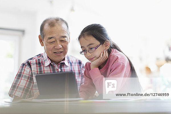 Grandfather and granddaughter using digital tablet