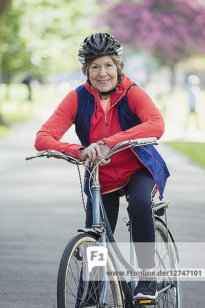 Portrait smiling  confident active senior woman riding bike in park