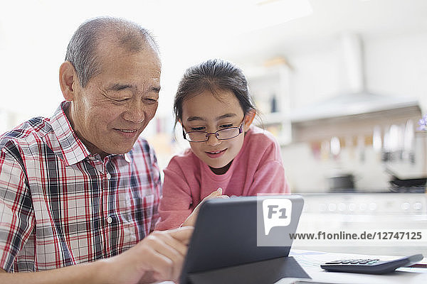 Grandfather and granddaughter using digital tablet