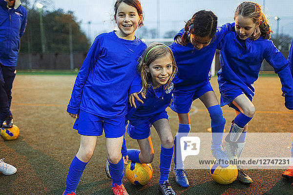 Porträt einer glücklichen Mädchenfußballmannschaft auf dem Spielfeld