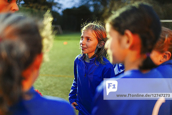 Aufmerksames Mädchenfußballteam hört dem Trainer zu