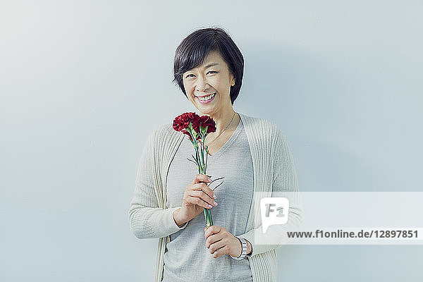 Japanische ältere Frau hält Blumen