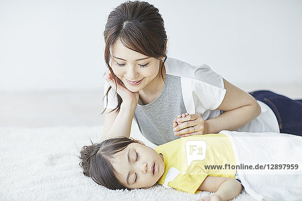 Japanische Mutter mit schlafendem Kind