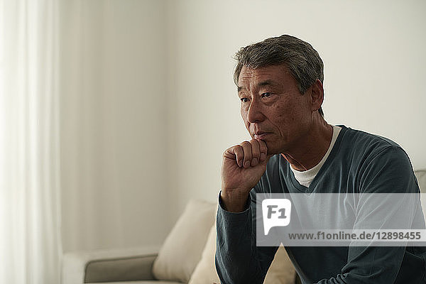 Japanischer älterer Mann auf dem Sofa