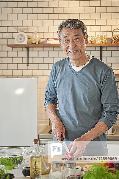 Japanischer älterer Mann in der Küche