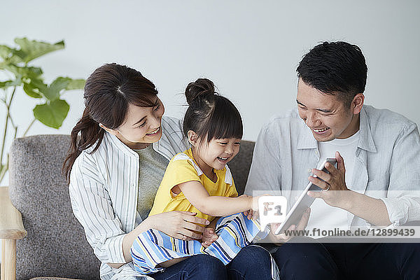 Japanische Familie auf dem Sofa