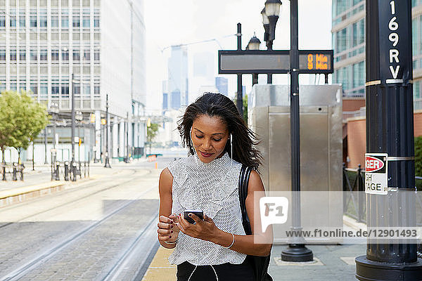 Geschäftsfrau benutzt Mobiltelefon auf der Straße