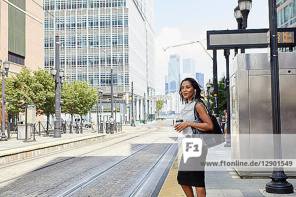 Geschäftsfrau wartet auf Stadtbahnsteig
