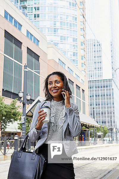Businesswoman using cellphone in street