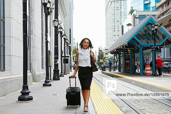 Geschäftsfrau  die Gepäck neben dem Zug zieht