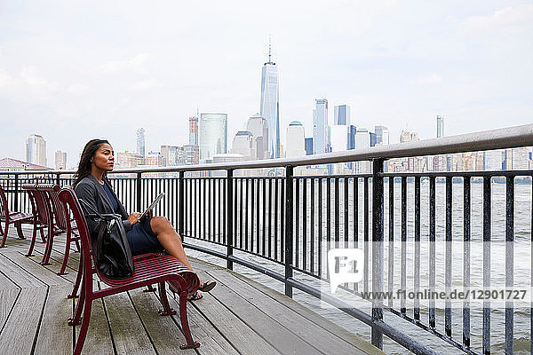 Businesswoman using digital tablet  New York City skyline in background
