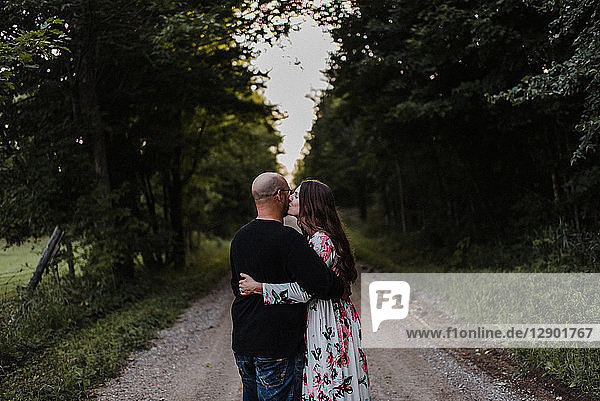 Couple hugging on countryside road