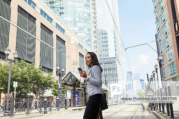 Businesswoman crossing light rail tracks