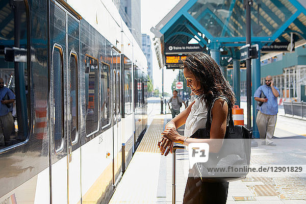 Geschäftsfrau kontrolliert Zeit bei Stadtbahnlinie