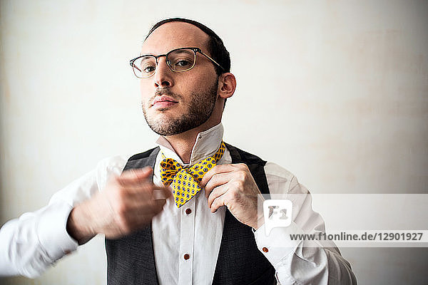 Businessman putting on bow tie