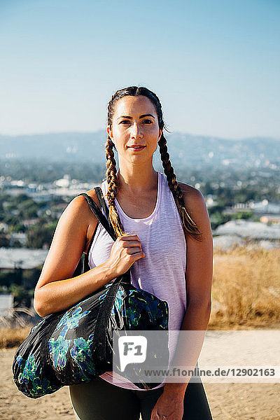 Woman carrying sports bag on hilltop  Los Angeles  US