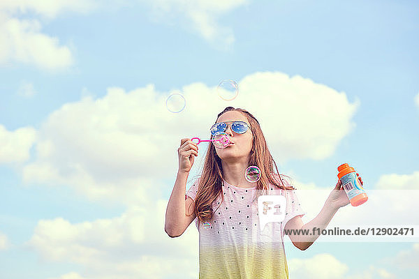 Mädchen spielt mit Seifenblasen