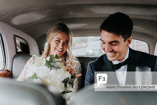 Braut und Bräutigam auf dem Rücksitz des Autos