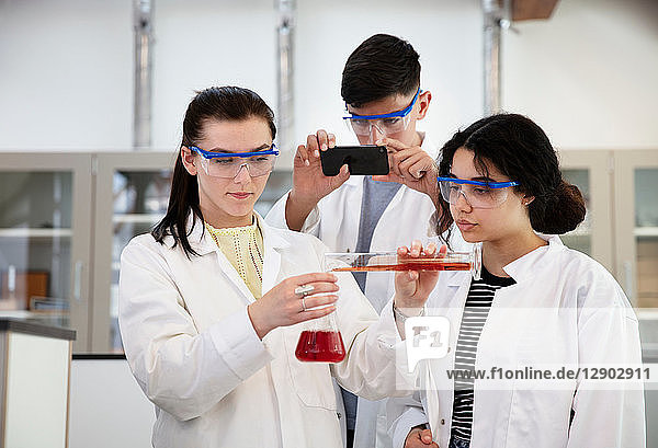 Students pouring sample into flask in laboratory