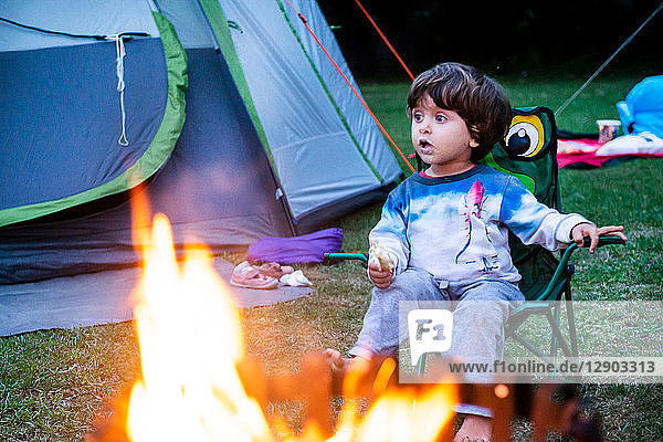 Child relaxing in front of bonfire