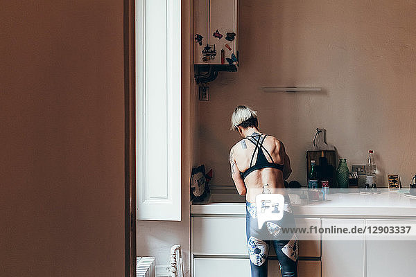 Frau beim Aufräumen in der Küche