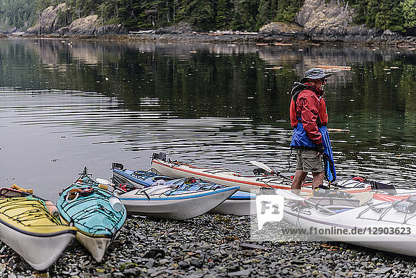 Man with sea kayaks on lakeside  Johnstone Strait  Telegraph Cove  Canada
