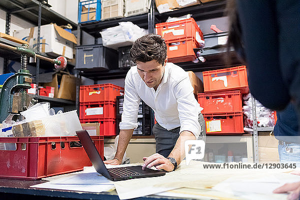 Man using laptop in demonstration in warehouse