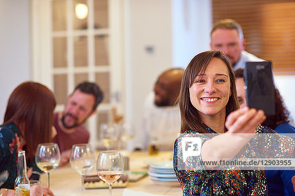 Friends taking selfie at dinner party