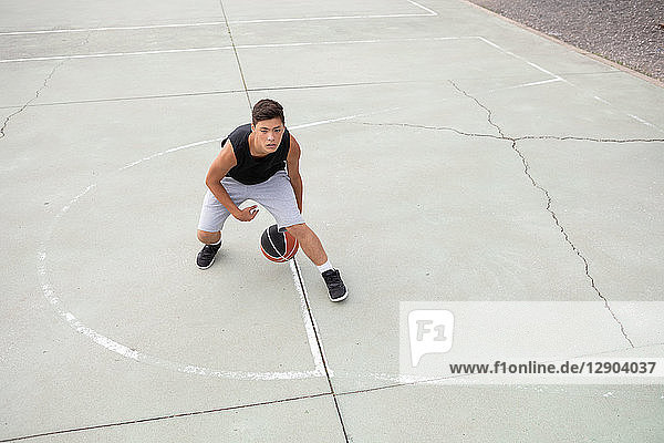 Männlicher jugendlicher Basketballspieler beim Üben auf dem Basketballfeld  Hochwinkelansicht