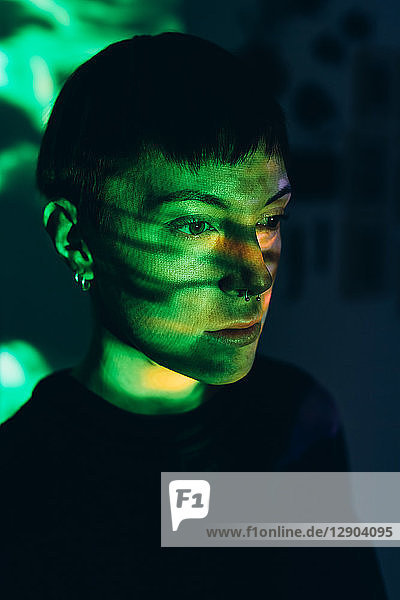 Tagträumende Frau  grünes Licht auf dem Gesicht reflektiert