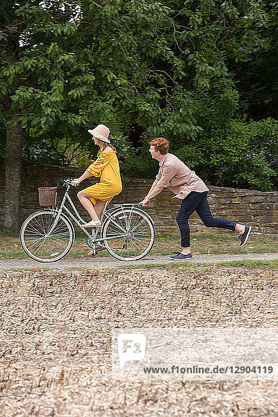 Couple with pushbike in countryside