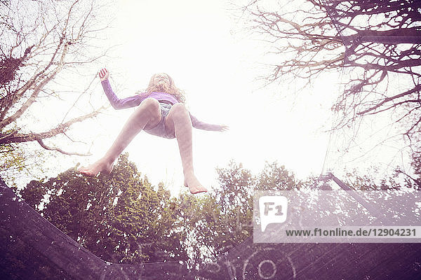 Mädchen springt auf Trampolin  niedriger Blickwinkel