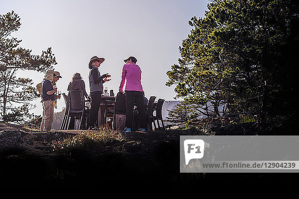 Friends talking at dinner on cliff top  Johnstone Strait  Telegraph Cove  Canada