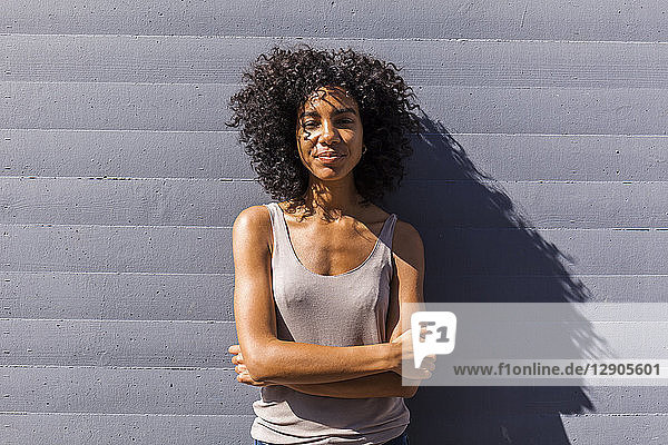 Portrait of content young woman with curly hair in summer