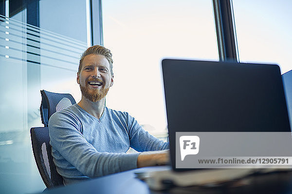 Happy businessman at desk in office