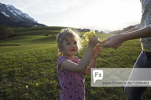 Austria  Tyrol  Walchsee  portrait of girl with mother holding flowers on an alpine meadow