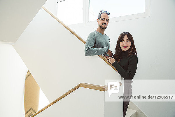 Business couple standing on stairs of their office
